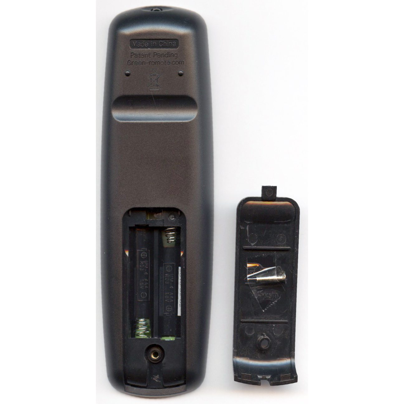 Back view of the Anderic RRHC100 EzWipe Hospitality Universal Remote Control for TV and Cable with its battery cover off, revealing two empty slots. The easy-wipe surface ensures cleanliness, and the cover rests neatly beside the remote.
