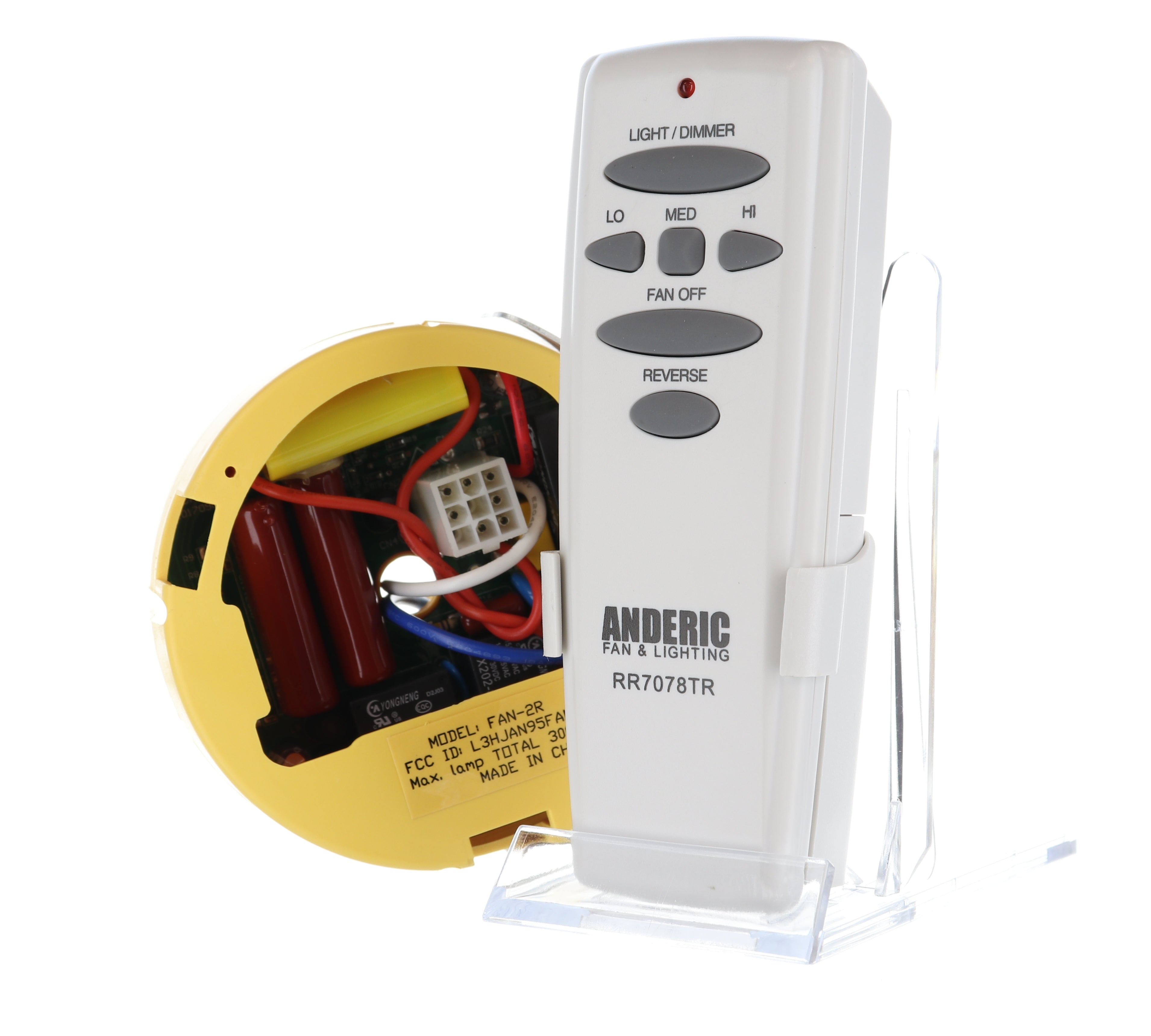 A white Anderic FAN2R/RR7078TR remote control for Hampton Bay/HUNTER ceiling fan rests on a stand beside a yellow circular device with exposed wiring.