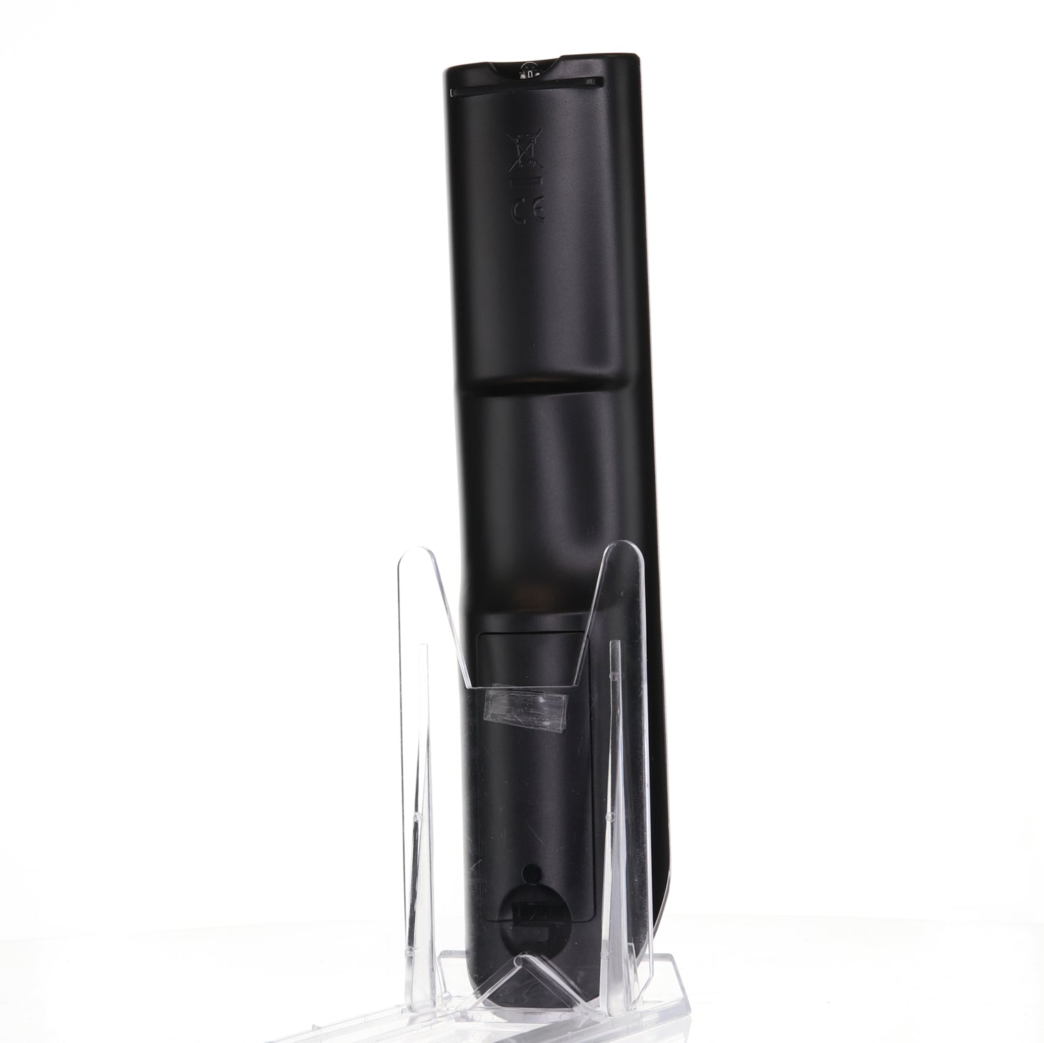A black Anderic 076R0LJ030 remote for Sansui TV/DVD combo (RMC12052) stands upright in a clear plastic stand on a white surface.